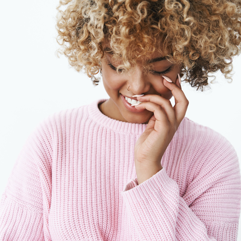 happy young woman looking down and smiling