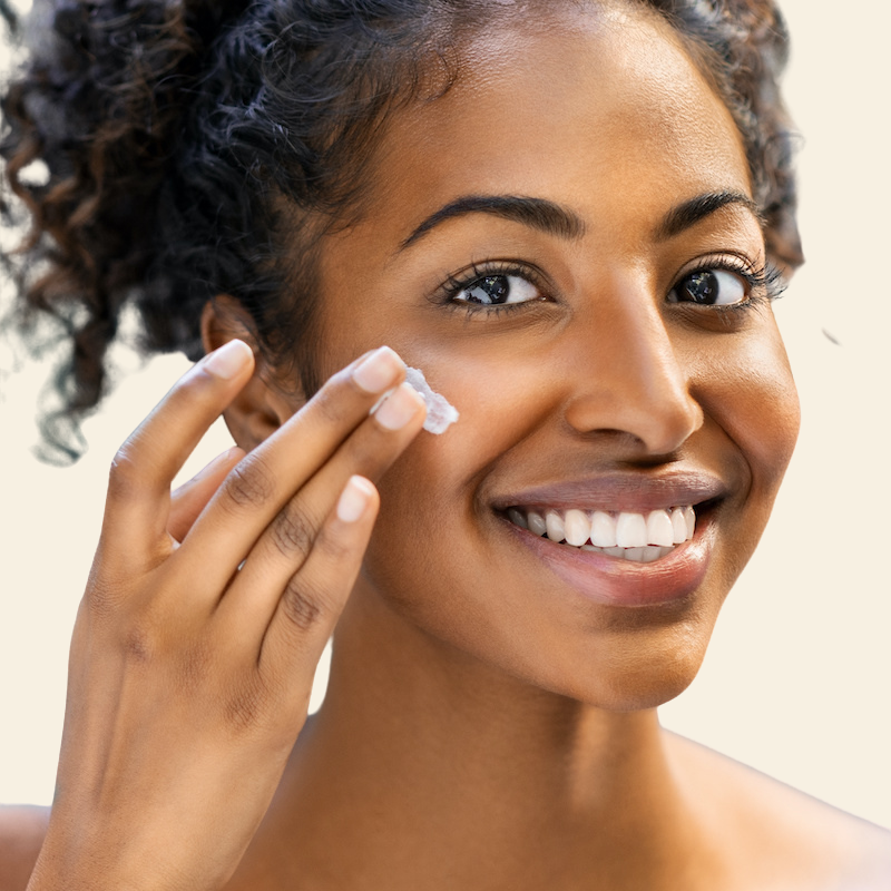 young woman applying skincare cream